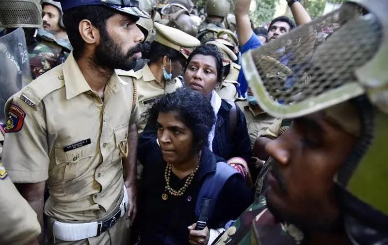 Indian police escort Hindu devotees Kanaga Durga (C bottom) and Bindu (C top) after their group of women were stopped by hardline activists during an effort to reach the Sabarimala Ayyapa temple from Pamba in the southern state of Kerala on December 24, 2018. - Hundreds of Hindu activists on December 24 blocked a path leading to one of the religion's holiest temples in southern India to stop a group of women making a new attempt to reach the landmark, which has been opened to women devotees by an Indian Supreme Court order. (Photo by - / AFP)