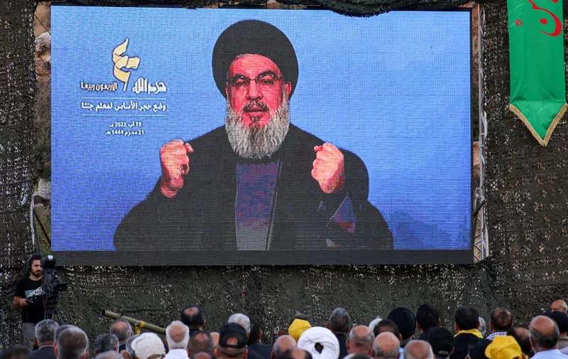 Supporters of the Lebanese Shiite Muslim movement Hezbollah attend a televised speech by the group's leader Hassan Nasrallah during a ceremony to lay the foundation for a site for "jihadist tourism", at a camp formerly run by Iran's Islamic Revolutionary Guard Corps (IRGC) in Lebanon to train Hezbollah fighters, in the Janta region in the east of the country on August 19, 2022. (Photo by AFP)