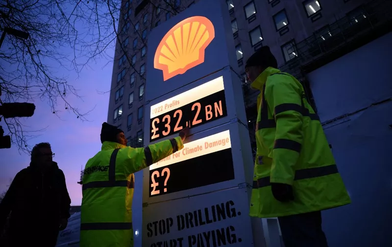Activists from Greenpeace set up a mock-petrol station price board displaying the Shell's net profit for 2022, as they demonstrate outside the company's headquarters in London on February 2, 2023, as the British energy company announce their full-year results. - Shell net profit surged to a record $42.3 billion last year, the British energy giant said Thursday, as Russia's invasion of Ukraine sent oil and gas prices soaring. The post-tax figure was more than double the amount achieved in 2021, the group's earnings statement revealed. (Photo by Daniel LEAL / AFP)