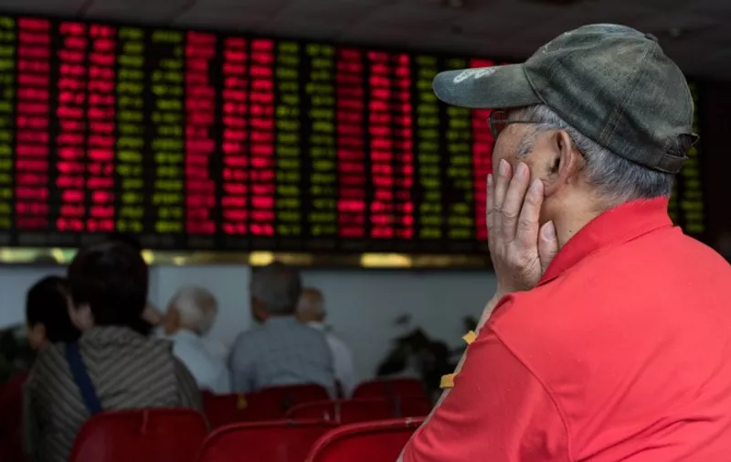 This photo taken on August 13, 2015 shows investors monitoring screens showing stock market movements at a brokerage house in Shanghai. Shanghai stocks were down 0.40 percent, or 15.01 points to 3,779.10, by the break on August 20, 2015, narrowing morning losses on expectations of more government support measures for equities following volatile trading the previous day, dealers said.       AFP PHOTO / JOHANNES EISELE