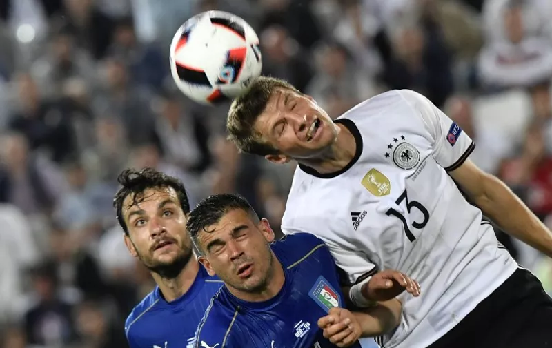 Italy's midfielder Stefano Sturaro and Germany's midfielder Thomas Mueller jump for the ball during the Euro 2016 quarter-final football match between Germany and Italy at the Matmut Atlantique stadium in Bordeaux on July 2, 2016.
 / AFP PHOTO / GEORGES GOBET