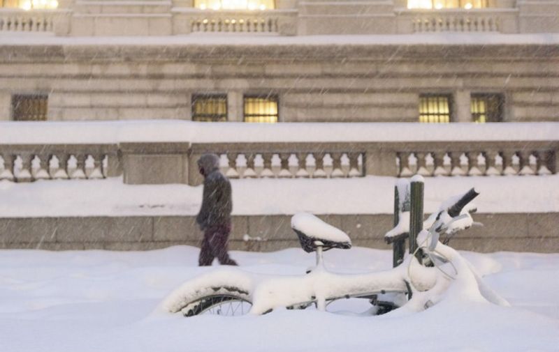 A man walks by the New York Public Library near cycles burried under the snow during a snowstorm January 23, 2016 in New York.
A deadly blizzard with bone-chilling winds and potentially record-breaking snowfall slammed the eastern US on Saturday, as officials urged millions in the storm's path to seek shelter -- warning the worst is yet to come. / AFP / FRANCOIS XAVIER MARIT