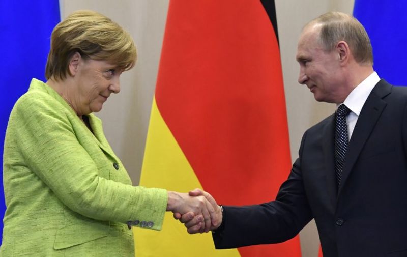 Russian President Vladimir Putin shakes hands with German Chancellor Angela Merkel after a press conference following their meeting at the Bocharov Ruchei state residence in Sochi on May 2, 2017. / AFP PHOTO / Alexander NEMENOV