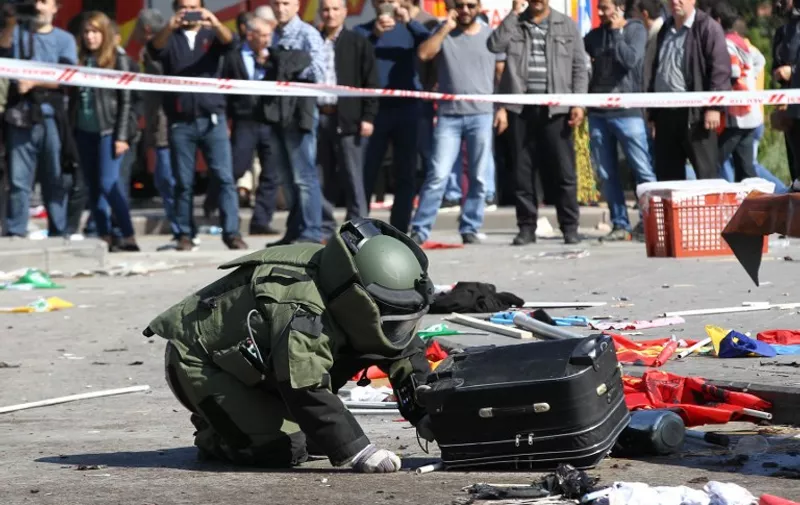 A bomb-disposal expert inspects a suitcase at the site of twin explosions near the main train station in Turkey's capital Ankara, on October 10, 2015. At least 86 people were killed on October 10 in the Turkish capital Ankara when bombs set off by two suspected suicide attackers ripped through leftist and pro-Kurdish activists gathering for an anti-government peace rally, the deadliest attack in the history of modern Turkey. AFP PHOTO / ADEM ALTAN