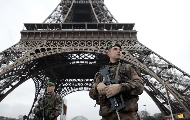 French soldiers patrol in front of the Eiffel Tower on January 7, 2015 in Paris as the capital was placed under the highest alert status after heavily armed gunmen shouting Islamist slogans stormed French satirical newspaper Charlie Hebdo and shot dead at least 12 people in the deadliest attack in France in four decades. Police launched a massive manhunt for the masked attackers who reportedly hijacked a car and sped off, running over a pedestrian and shooting at officers. AFP PHOTO / JOEL SAGET
