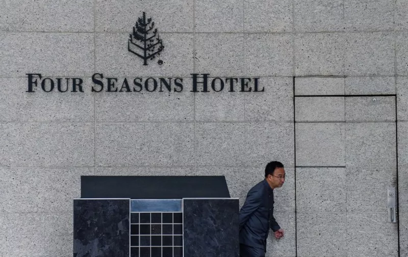 A member of staff walks outside the Four Seasons Hotel in Hong Kong on February 1, 2017.
A Chinese billionaire has been abducted in Hong Kong by mainland agents, according to reports on January 31, triggering more concerns over security in the city after the disappearance of five booksellers. Financier Xiao Jianhua, founder of Beijing-based Tomorrow Group, was staying long-term at Hong Kong's luxury Four Seasons hotel, according to reports in overseas Chinese-language media.  / AFP PHOTO / Anthony WALLACE