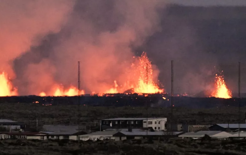 Lava explosions are seen near residential buildings in the southwestern Icelandic town of Grindavik after a volcanic eruption on January 14, 2024. Seismic activity had intensified overnight and residents of Grindavik were evacuated, Icelandic public broadcaster RUV reported. This is Iceland's fifth volcanic eruption in two years, the previous one occurring on December 18, 2023 in the same region southwest of the capital Reykjavik. Iceland is home to 33 active volcano systems, the highest number in Europe. (Photo by Halldor KOLBEINS / AFP)