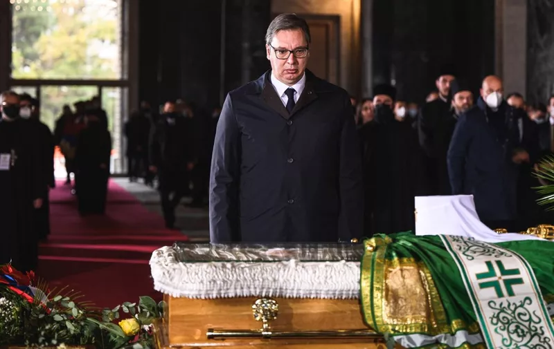 Serbian President Aleksandar Vucic pays his last respect next to the casket of late Serbian patriarch Irinej during a funeral service at Belgrade's Saint Sava temple, on November 22, 2020. - Patriarch Irinej, the head of the Serbian Orthodox Church, died of coronavirus on November 20, 2020, three weeks after his unofficial second-in-command also succumbed to Covid-19, the church said. (Photo by Andrej ISAKOVIC / AFP)