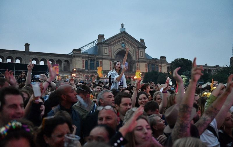 Festival-goers attend the Kaleidoscope Festival in Alexandra Palace Park in London on July 24, 2021. - The one-day Kaleidoscope festival is set to play a full-line up in one of the first large festival events to take place in England since the lifting of almost all Covid-19 restrictions. (Photo by JUSTIN TALLIS / AFP)