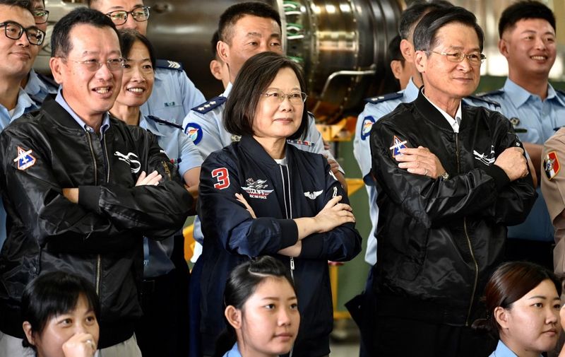 (FILES) In this file photo taken on September 26, 2020 Taiwan President Tsai Ing-wen (C) poses for photographs while visiting a turboprop engine factory at a military base in Kaohsiung. - Taiwan's president said October 27, 2021 she has "faith" the United States would defend the island against a Chinese attack, as Beijing and Washington trade barbs over Taipei's place on the global stage. Tsai Ing-wen also confirmed for the first time that US troops were training Taiwanese forces on the island in an interview with CNN broadcast Wednesday -- an initiative first confirmed to AFP by a Pentagon official earlier this month. (Photo by Sam Yeh / AFP)