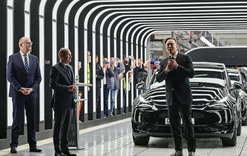 Tesla CEO Elon Musk (R), German Chancellor Olaf Scholz (C) and Brandenburg State Premier Dietmar Woidke attend the start of the production at Tesla's "Gigafactory" on March 22, 2022 in Gruenheide, southeast of Berlin. US electric car pioneer Tesla received the go-ahead for its "gigafactory" in Germany on March 4, 2022, paving the way for production to begin shortly after an approval process dogged by delays and setbacks. (Photo by Patrick Pleul / POOL / AFP)