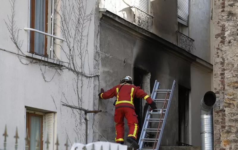 A firefigher inspects a burnt window after a fire broke up in the night killing three people and injured eight others, in Stains, Paris' suburb, on November 25, 2023. The fire broke out at around 2.00 am on the ground floor of the building, which has three floors, a police source said. By mid-morning, the fire had been extinguished. (Photo by Geoffroy VAN DER HASSELT / AFP)