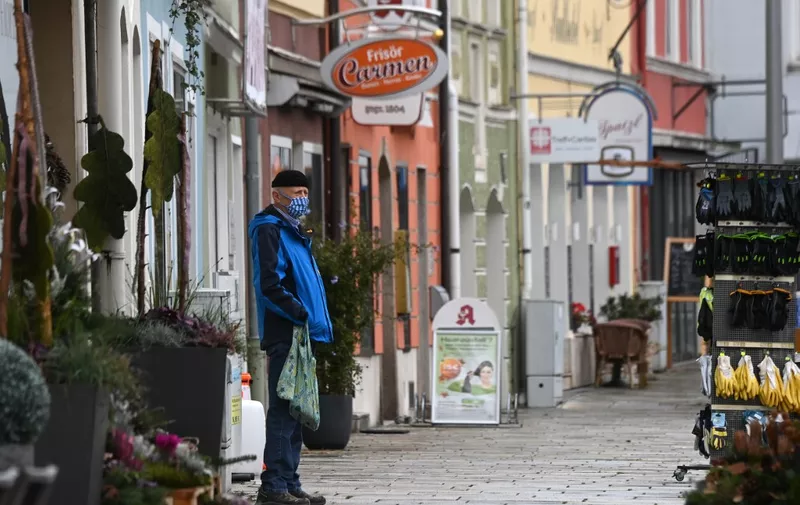 A man wears a face mask while standing on a street in Pfarrkirchen, a town of the county district Rottal-Inn in Bavaria, on October 27, 2020 after a local lockdown was imposed because of the coronavirus Covid-19 pandemic. (Photo by Christof STACHE / AFP)