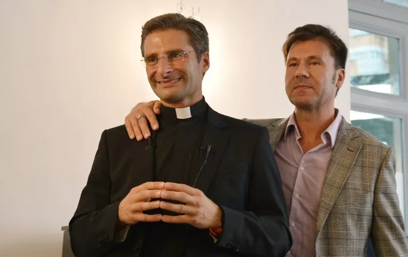 Father Krysztof Olaf Charamsa (L), who works for a Vatican office, gives a press conference with his partner Edouard to reveal his homosexuality on October 3, 2015 in Rome. The priest said he wanted to challenge what he termed the Church's "paranoia" with regard to sexual minorities, claiming the Catholic clergy was largely made up of intensely homophobic homosexuals. The Vatican condemned the coming out of a Polish priest on the eve of a major synod as a "very serious and irresponsible," act which meant he would be stripped of his responsibilities in the Church's hierarchy. In a statement, a spokesman said Krzystof Charamsa would not be able to continue in his senior position in the Vatican and that his future as a priest would be decided by his local bishop.  AFP PHOTO / TIZIANA FABI