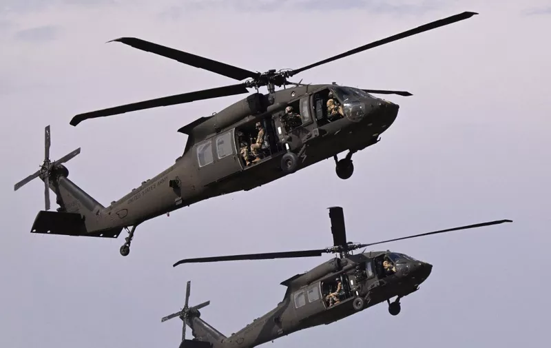 Military personnel of the US Army's 101st Airborne Division take off with Black Hawk helicopters during a demonstration drill at Mihail Kogalniceanu Airbase near Constanta, Romania on July 30, 2022. - Members of the 101st Airborne Division (Air Assault) headquarters and its 2nd Brigade Combat Team in a ceremony marked their official arrival in Europe at the airbase. The ceremony was followed by a 'Romania/US Air and Land Showcase', a combined US Army and Romanian Army capabilities demonstration. (Photo by Daniel MIHAILESCU / AFP)