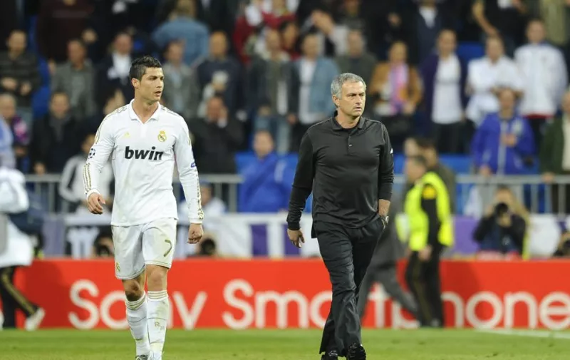 Real Madrid's Portuguese coach Jose Mourinho (R) walks with Real Madrid's Portuguese forward Cristiano Ronaldo at the end of the UEFA Champions League round of 16 second-leg match Real Madrid vs CSKA Moskva at the Santiago Bernabeu stadium in Madrid on March 14, 2012.  AFP PHOTO/ PIERRE-PHILIPPE MARCOU