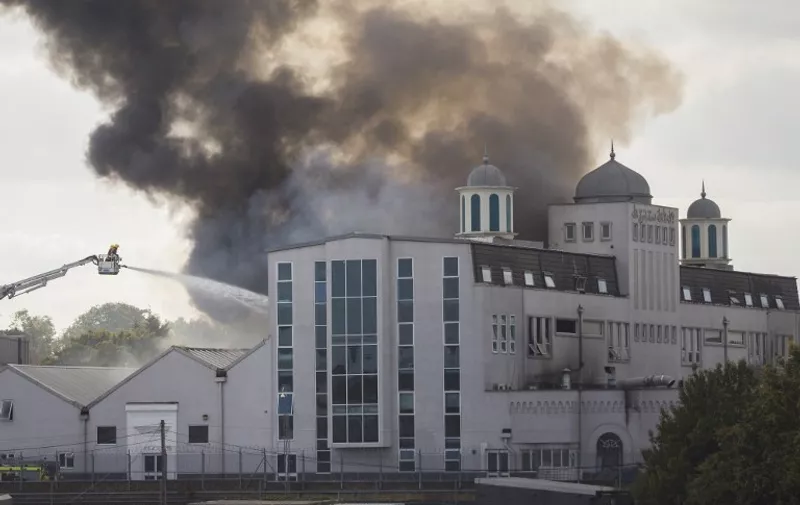 Firefighters tackle a blaze at the Baitul Futuh Mosque in Morden, south west London on September 26, 2015. Around 70 firefighters are tackling the blaze which broke out around midday today.
AFP PHOTO / JACK TAYLOR