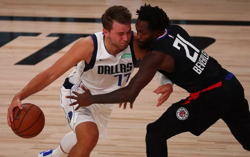 LAKE BUENA VISTA, FLORIDA - AUGUST 17: Luka Doncic #77 of the Dallas Mavericks drives against Patrick Beverley #21 of the LA Clippers in the first half during Game One of the 2020 NBA Playoffs at AdventHealth Arena at the ESPN Wide World Of Sports Complex on August 17, 2020 in Lake Buena Vista, Florida. NOTE TO USER: User expressly acknowledges and agrees that, by downloading and or using this photograph, User is consenting to the terms and conditions of the Getty Images License Agreement. (Photo by Kim Klement-Pool/Getty Images)