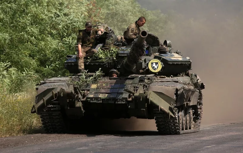 Ukrainian soldiers ride a tank on a road in the Donetsk region on July 20, 2022, near the front line between Russian and Ukrainian forces. - Russia said Wednesday that holding peace talks with Ukraine made no sense "in the current situation" as Moscow presses ahead with its offensive in the pro-Western country. Russia's top diplomat also said that Moscow's military aims in Ukraine were no longer focused "only" on the country's east, adding that supplies of Western weapons had changed the Kremlin's calculus. (Photo by Anatolii Stepanov / AFP)