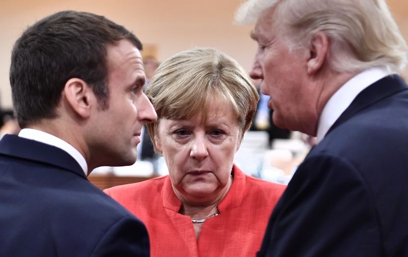 (L-R) French President Emmanuel Macron, German Chancellor Angela Merkel and US President Donald Trump confer at the start of the first working session of the G20 meeting in Hamburg, northern Germany, on July 7. - Leaders of the world's top economies will gather from July 7 to 8, 2017 in Germany for likely the stormiest G20 summit in years, with disagreements ranging from wars to climate change and global trade. (Photo by John MACDOUGALL / various sources / AFP)