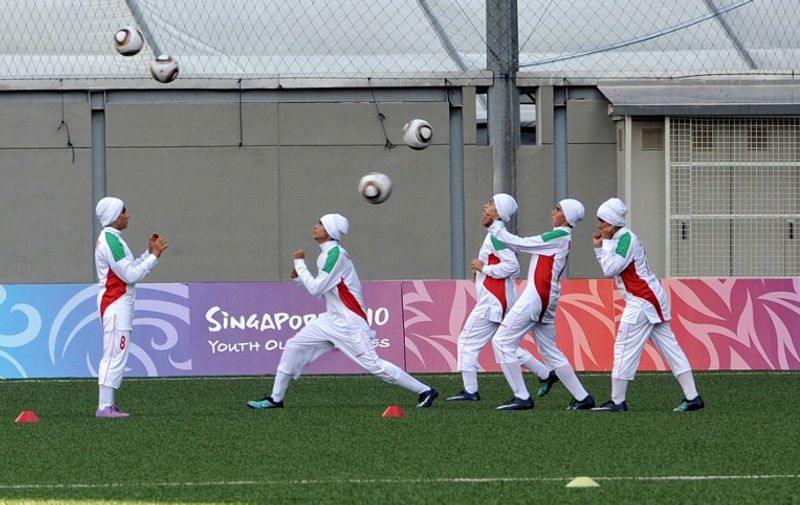 Iranian female football players warm-up before their opening match against Turkey in the Womens' Youth Olympic Football Tournaments 2010 in Singapore on August 12, 2010.   AFP PHOTO/ROSLAN RAHMAN