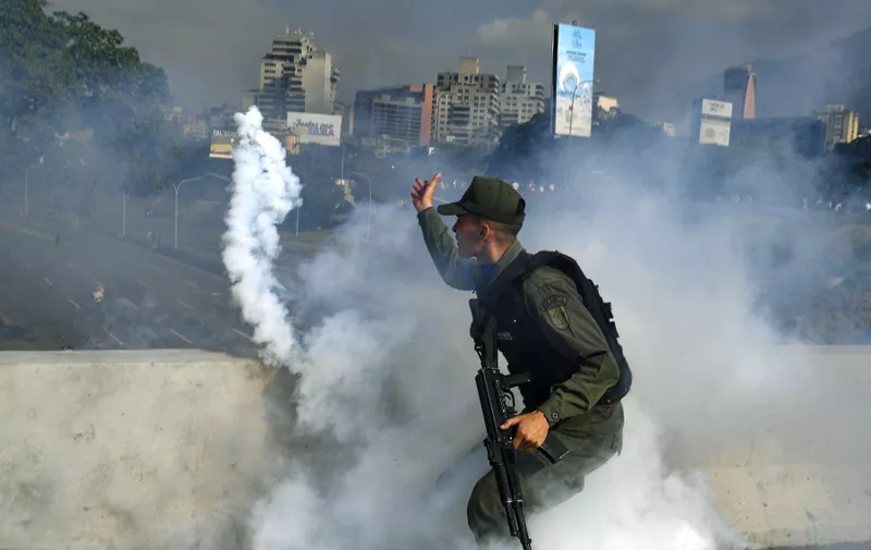 A member of the Bolivarian National Guard supporting Venezuelan opposition leader and self-proclaimed acting president Juan Guaido throws a tear gas canister during a confrontation with guards loyal to President Nicolas Maduro's government in front of La Carlota military base in Caracason April 30, 2019. Guaido said on Tuesday that troops had joined his campaign to oust President Nicolas Maduro as the government vowed to put down what it called an attempted coup., Image: 429882305, License: Rights-managed, Restrictions: , Model Release: no, Credit line: Profimedia, AFP