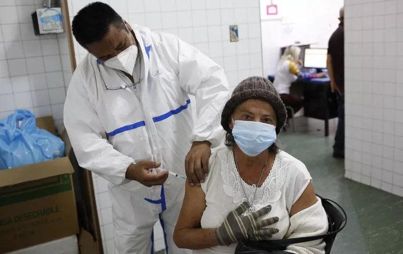 A health worker administers a dose of the Sputnik V vaccine against COVID-19 to an eldery woman at the Victorino Santaella Hospital in Los Teques, Venezuela on April 9, 2021, amid the ongoing coronavirus pandemic. - Like the rest of South America, Venezuela is battling a harsh new pandemic wave fueled, authorities say, by more infectious virus variants from Brazil. (Photo by Pedro Rances Mattey / AFP)