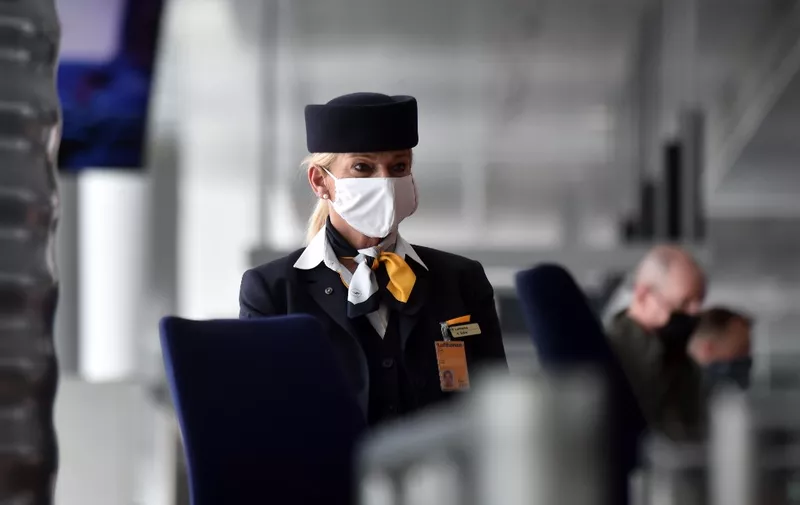 An employee of the German airline Lufthansa wears a protective mask at a gate of the company's terminal at the "Franz-Josef-Strauss" airport in Munich, southern Germany, on June 3, 2020. - An aircraft of German airline giant Lufthansa flew nonstop to Los Angeles for the first time since March 13, 2020, a day after one flew from Munich to Chicago. Lufthansa said it will undergo "far-reaching" restructuring as it  posted a first-quarter net loss of 2.1 billion euros ($2.3 billion) on Wednesday, hammered by the coronavirus pandemic. (Photo by Christof STACHE / AFP)