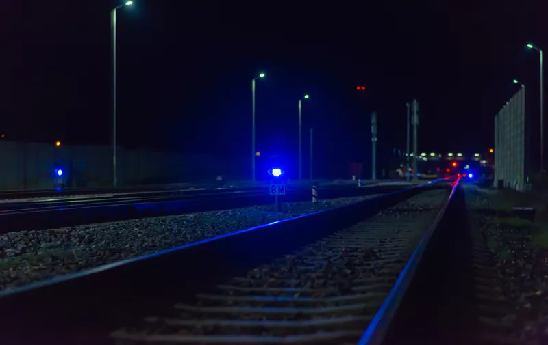 Night empty railroad tracks near train station with lights in dark night.A train station near railway.Photo from railway.Selective focus.,Image: 629512410, License: Royalty-free, Restrictions: , Model Release: yes