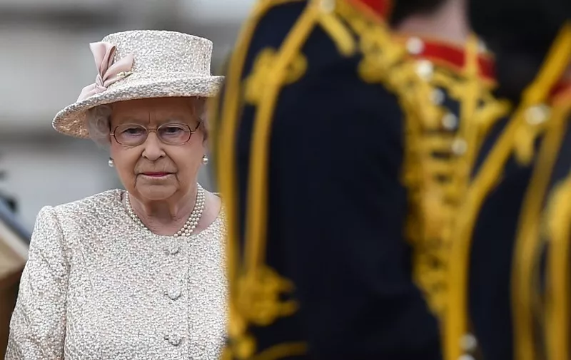 Britain's Queen Elizabeth II stands to recieve salutes in the forecourt of Buckingham Palace during the Queen's Birthday Parade, 'Trooping the Colour,' in London on June 13, 2015. The ceremony of Trooping the Colour is believed to have first been performed during the reign of King Charles II. In 1748, it was decided that the parade would be used to mark the official birthday of the Sovereign. More than 600 guardsmen and cavalry make up the parade, a celebration of the Sovereign's official birthday, although the Queen's actual birthday is on 21 April.  AFP PHOTO / BEN STANSALL