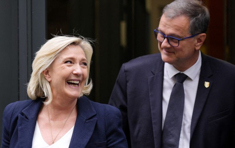 Former president of the French far-right Rassemblement National (RN) parliamentary group Marine Le Pen and RN Mayor of Perpignan Louis Aliot leave the party's headquarters in Paris on July 2, 2024. French people go to polls on July 7, 2024 for the decisive final round of the snap election the president called after his camp received a drubbing in European elections last month. (Photo by Dimitar DILKOFF / AFP)
