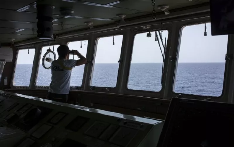 A member of the Aquarius rescue ship of the European search and rescue association "SOS Mediterranee", uses binoculars during a search operation on the Mediterranean Sea, 20 nautical miles from the Libyan coast, on August 11, 2017.
The Libyan navy on August 11, 2017, ordered foreign vessels to stay out of a coastal "search and rescue zone" for migrants headed for Europe, a measure it said targeted NGOs. / AFP PHOTO / Angelos Tzortzinis
