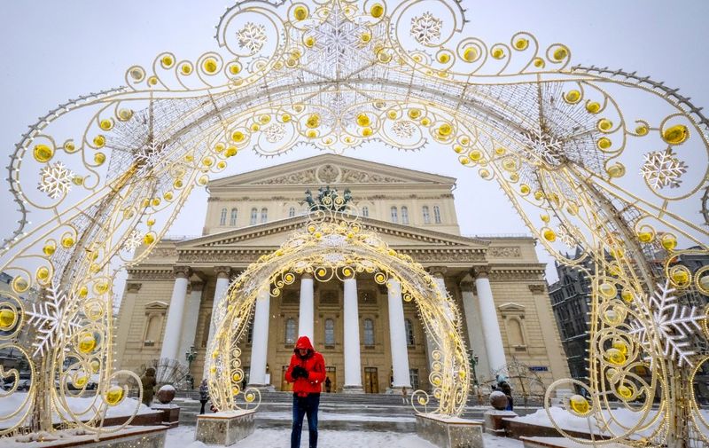 A man walks in the snow in front of the Bolshoi theatre in central Moscow on February 21, 2021. (Photo by Yuri KADOBNOV / AFP)