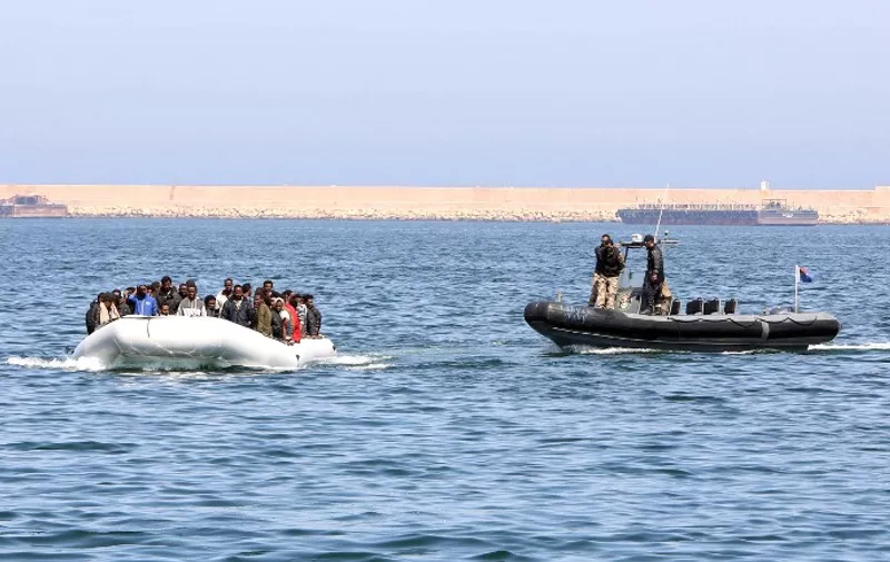 Libyan coast guards escort a boat carrying illegal migrants, who had hoped to set off to Europe with the help of people smugglers from the coastal town of Garabulli, towards the Libyan navy to the capital, Tripoli, prior to their arrest on June 6, 2015. Libya has a coastline of 1,770 kilometres (more than 1,000 miles). It is just 300 kilometres from the Italian island of Lampedusa, which many migrants fleeing poverty and conflict aim for as their gateway to Europe. AFP PHOTO / MAHMUD TURKIA