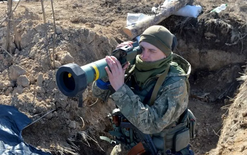 A serviceman of Ukrainian military forces holds a FGM-148 Javelin, an American-made portable anti-tank missile, at a checkpoint, where they hold a position near Kharkiv on March 23, 2022. (Photo by Sergey BOBOK / AFP)