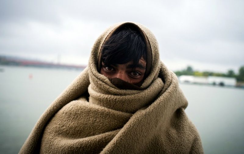 A migrant poses for a photograph while wrapped in a blanket as he shelters under a bridge in Belgrade on June 24, 2015.   Illegal immigrants cross Serbia on their way to other European countries as it has land access to three members of the 28-nation bloc -- Romania, Hungary and Croatia. The number of immigrants entering Hungary rose from 2,000 in 2012 to 54,000 this year so far. According to official figures, 95 percent of them arrive from Serbia.  AFP PHOTO / ANDREJ ISAKOVIC