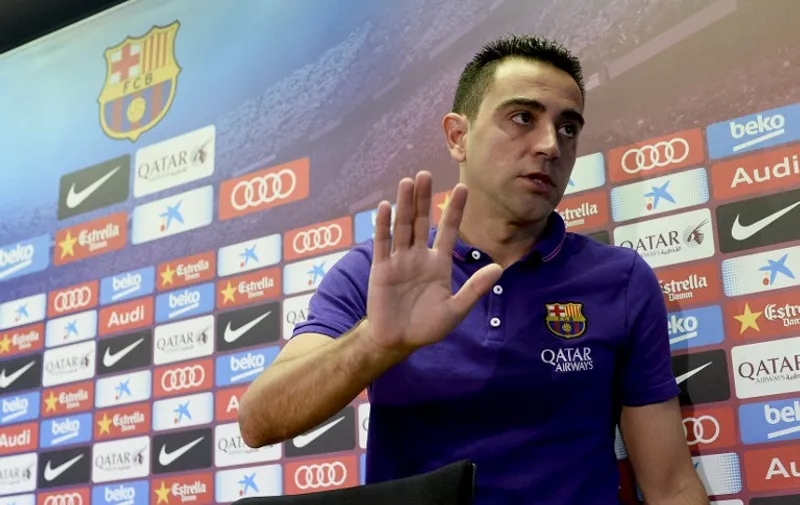 Barcelona's midfielder Xavi Hernandez waves at the end of a press conference at the Sports Center FC Barcelona Joan Gamper in Sant Joan Despi, near Barcelona on May 21, 2015. Barcelona legend Xavi Hernandez confirmed today that he will end his 17-year playing career with the Catalans at the end of the season to join Qatari side Al Sadd.    AFP PHOTO / JOSEP LAGO
