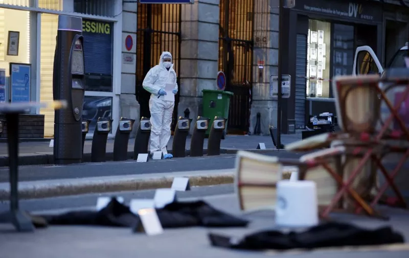 A forensic scientist inspects outside of the Cafe Bonne Biere on Rue du Faubourg du Temple in Paris on November 14, 2015, following a series of coordinated attacks in and around Paris late Friday, which left more than 120 people dead. According to witnesses, at least 5 people were killed in the immediate area by attackers wielding automatic rifles.