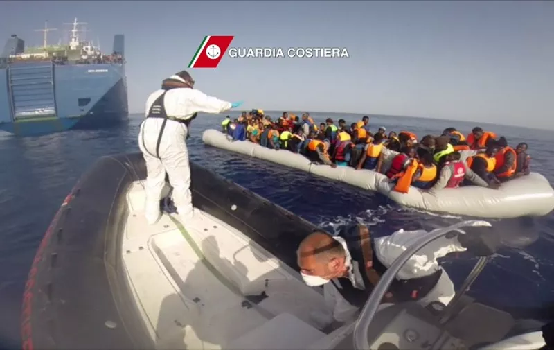 In this video grab released by the Italian Coast Guards (Guardia Costiera) on May 7, 2015 migrants sit in a boat during a rescue operation, yesterday, off the coast of Sicily as part of the Frontex-coordinated Operation Triton.  AFP PHOTO / HO
= RESTRICTED TO EDITORIAL USE - MANDATORY CREDIT "AFP PHOTO / GUARDIA COSTIERA" - NO MARKETING NO ADVERTISING CAMPAIGNS - DISTRIBUTED AS A SERVICE TO CLIENTS =