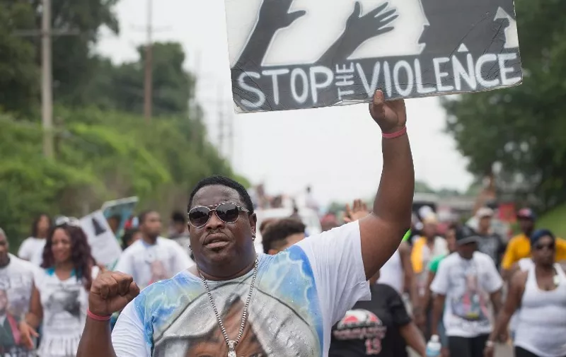 ST. LOUIS, MO - AUGUST 08: : Demonstrators march from the location where Michael Brown was shot and killed in Ferguson, Missouri to Normandy High School, where he was a student, to mark the first anniversary of his death on August 8, 2015 in St. Louis, Missouri. Brown was shot and killed by a Ferguson police officer on August 9, 2014. His death sparked months of sometimes violent protests in Ferguson and drew nationwide focus on police treatment of black offenders.   Scott Olson/Getty Images/AFP