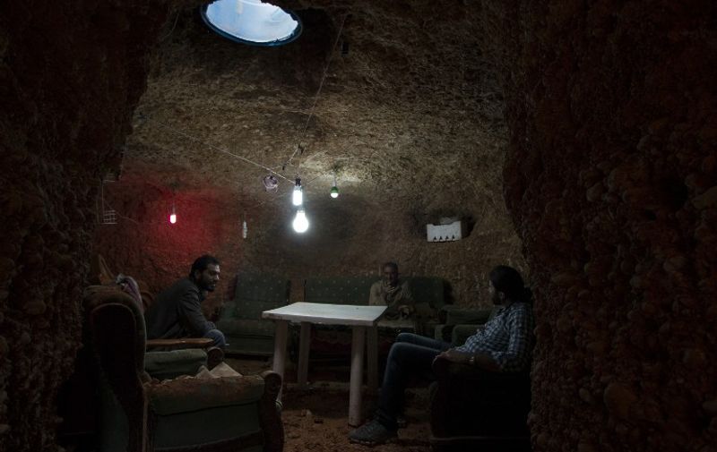 TOPSHOTS
Abu Amer (C), a former well driller, sits with family members inside their underground shelter in an Aleppo's southern suburb on October 29, 2015. The shelter which Abu Amer has been building for the past year, and will include four rooms equipped with ventilation and lighting, is expected to be completed in the coming months. AFP PHOTO / KARAM AL-MASRI