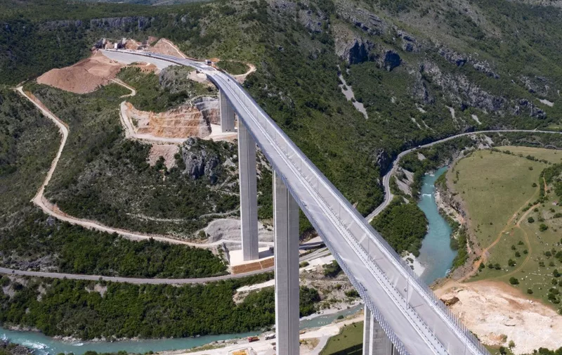 An aerial views shows a part of the new highway connecting the city of Bar on Montenegros Adriatic coast to landlocked neighbour Serbia, (Bar-Boljare highway) on May 11, 2021, near Matesevo, which is being constructed by China Road and Bridge Corporation (CRBC), the large state-owned Chinese company. - Two sleek new roads vanish into mountain tunnels high above a sleepy Montenegrin village, the unlikely endpoint of a billion-dollar project that is threatening to derail the tiny country's economy. The government has already burnt through $944 million in Chinese loans to complete the first stretch of road, just 41 kilometres (25 miles), making it among the world's most expensive pieces of tarmac. Chinese workers have spent six years carving tunnels through solid rock and raising concrete pillars above gorges and canyons, but the road in effect goes nowhere. Almost 130 kilometres still needs to be built at a likely cost of at least one billion euros ($1.2 billion). (Photo by SAVO PRELEVIC / AFP)