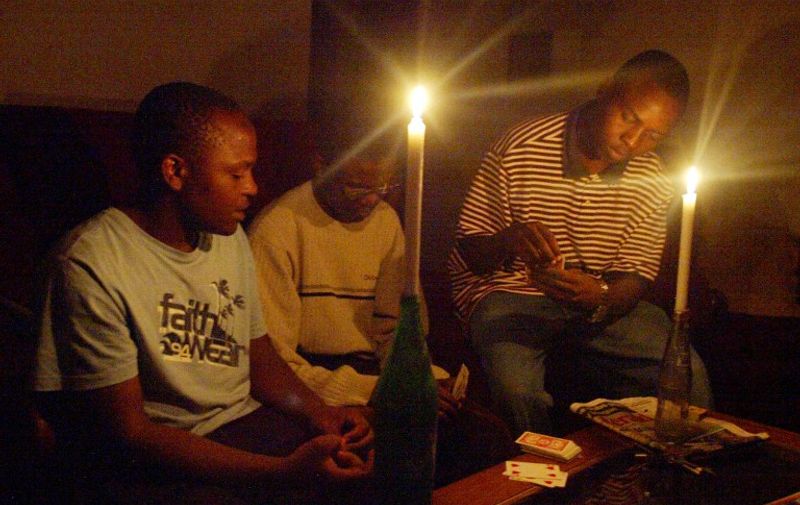 A Zimbabwean family plays card 21 January 2007 in Harare after the second power cut, which has hit most parts of the country.   Zimbabwe is experiencing a serious energy crisis with some areas going for up to 10 hours without electricity prompting many families to resort to using generators, firewood and candles for lighting. AFP PHOTO/Desmond Kwande