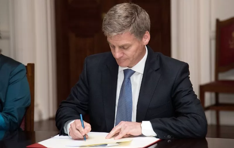 New Zealand's new Prime Minister Bill English signs the document that makes him Prime Minister at Government House in Wellington on December 12, 2016. 
New Zealand's ruling National Party appointed the experienced English as the country's new prime minister on December 12 following last week's shock resignation of his popular predecessor John Key. / AFP PHOTO