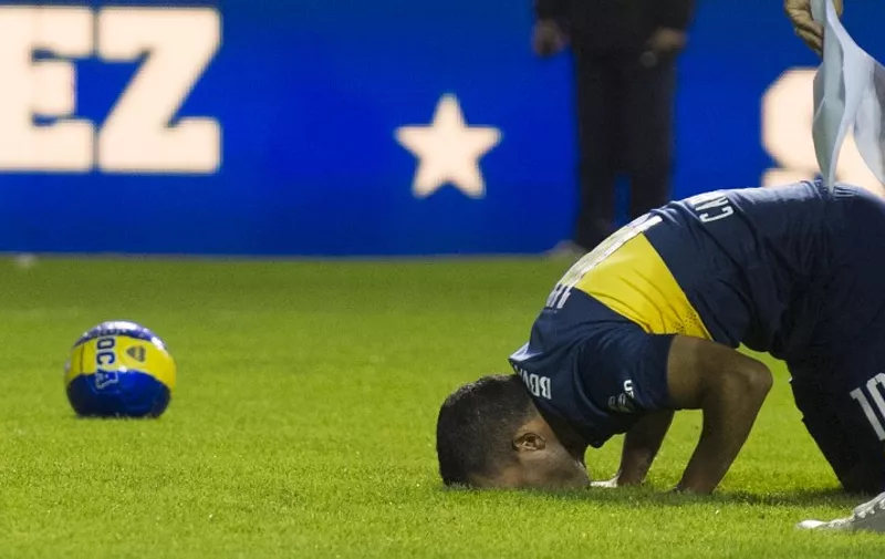 Boca Juniors' newly returned player Carlos Tevez kisses the field during his official presentation at La Bombonera stadium in Buenos Aires, on July 13, 2015.    AFP PHOTO / ALEJANDRO PAGNI