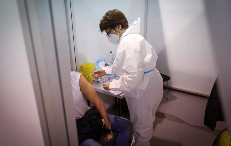 A man receives a dose of a Covid-19 vaccine in Belgrade Fair turned into a vaccination centre, on February 1, 2021. - Serbia continues a mass Covid-19 vaccination campaign and became the first European country to use Chinese-made Sinopharm vaccine, after receiving one million doses of the Sinopharm vaccine, on January 16, 2021. Beside the Chinese made jab, Serbian citizens can choose to receive either Sputnik V Gam-COVID-Vac or Pfizer-BioNTech Covid-19 vaccine. (Photo by OLIVER BUNIC / AFP)