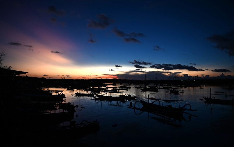 Fishing boats are seen moored at Serang beach near Denpasar on Indonesia's resort island of Bali on April 4, 2022. (Photo by SONNY TUMBELAKA / AFP)