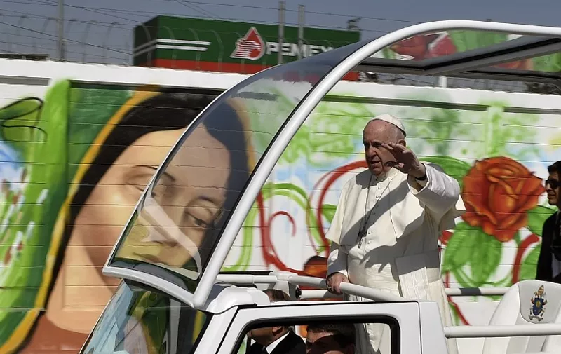 Pope Francis waves from the popemobile upon arrival in Ecatepec --a rough, crime-plagued Mexico City suburb-- where he is to celebrate an open-air mass, on February 14, 2016. Pope Francis has chosen to visit some of Mexico's most troubled regions during his five-day trip to the world's second most populous Catholic country.   AFP PHOTO / YURI CORTEZ / AFP / YURI CORTEZ