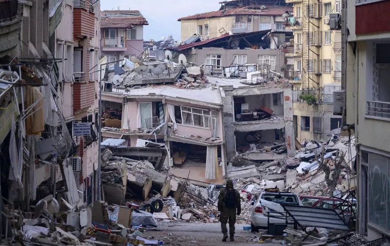 A Turkish soldier walks among destroyed buildings in Hatay, on February 12, 2023, after a 7.8-magnitude earthquake struck the country's south-east. - The death toll from a massive earthquake that hit Turkey and Syria climbed to more than 20,000 on February 9, 2023, as hopes faded of finding survivors stuck under rubble in freezing weather. (Photo by Yasin AKGUL / AFP)