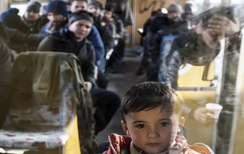 A boy is pictured as he waits with other migrants and refugees in a train after crossing the Macedonian border into Serbia, in the town of Presevo  on January 25, 2016. 
More than 1 million people from countries like Syria, Iraq or Afghanistan entered Europe last year in what has been called the biggest migration to the continent since World War II.  / AFP / ARMEND NIMANI